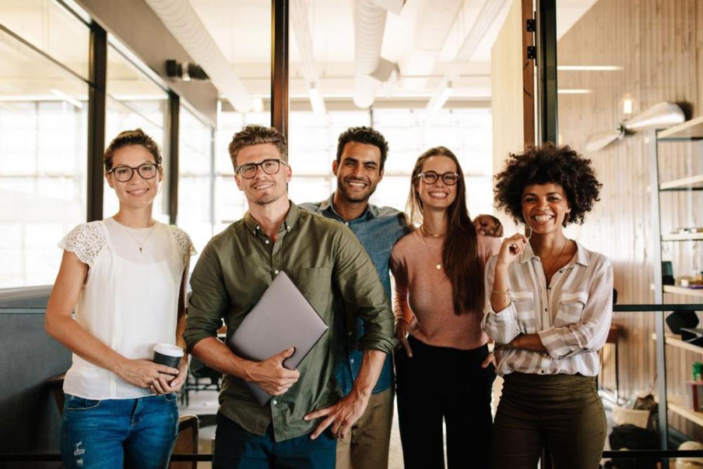 Young professional team smiling at camera in office