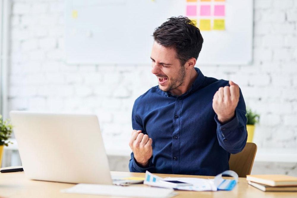 Happy man at home office desk