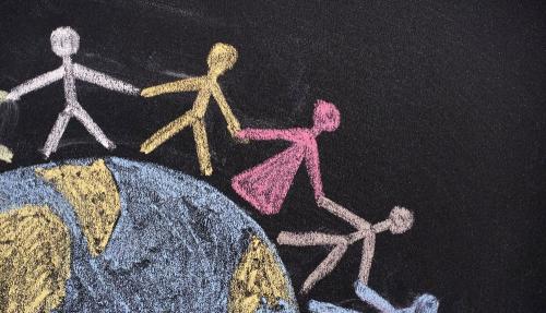 Chalk illustration of stick people holding hands around the world