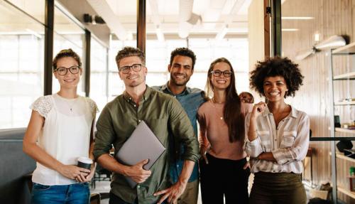 Young professional team smiling at camera in office