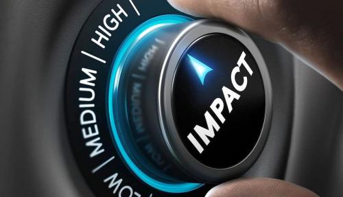 Closeup of hand turning big button that says impact