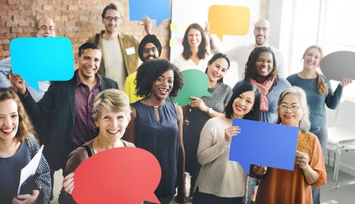Diverse group of people holding cardboard cutout speech bubbles