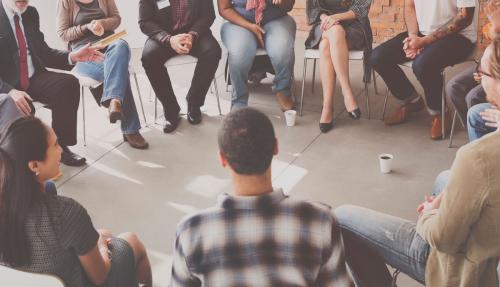 Group of people sitting in chairs in a circle