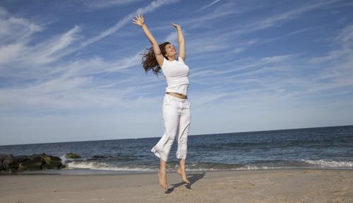 Lady on beach hands raised