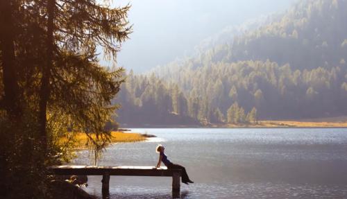 Man relaxing on jetty at lake